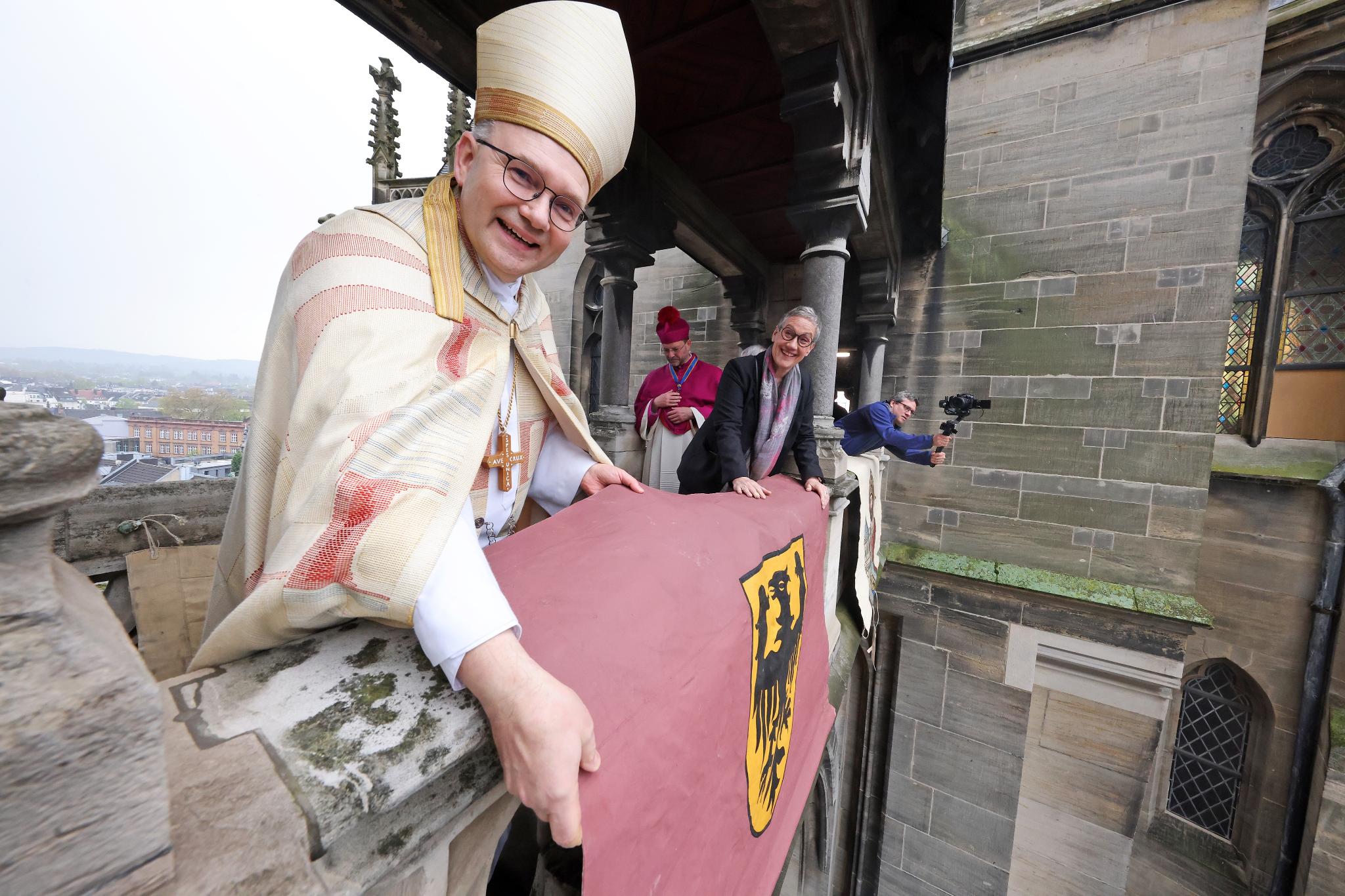 Mit einer feierlichen Vesper unter Beteiligung von Domchor und Domorchester und dem Auslegen der Schmucktücher ist die „heiße Phase“ der Heiligtumsfahrt 2023 eröffnet worden. Dompropst und Wallfahrtsleiter Rolf-Peter Cremer sprach die offizielle Einladung zur Heiligtumsfahrt aus. „Es sind noch 39 Tage, der Countdown läuft“, sagte er mit Nachdruck. Nach der Vesper wurden auf dem Balkon des Domes und der Galerie die Schmucktücher ausgelegt. „Diese Schmucktücher stammen aus dem Anfang des 19. Jahrhunderts, aus einer Zeit, als man keine Plakate hatte, aber Zeichen brauchte, die weithin sichtbar das Besondere, die Heiligtumsfahrt, ankündigen konnten“, berichtet Cremer.